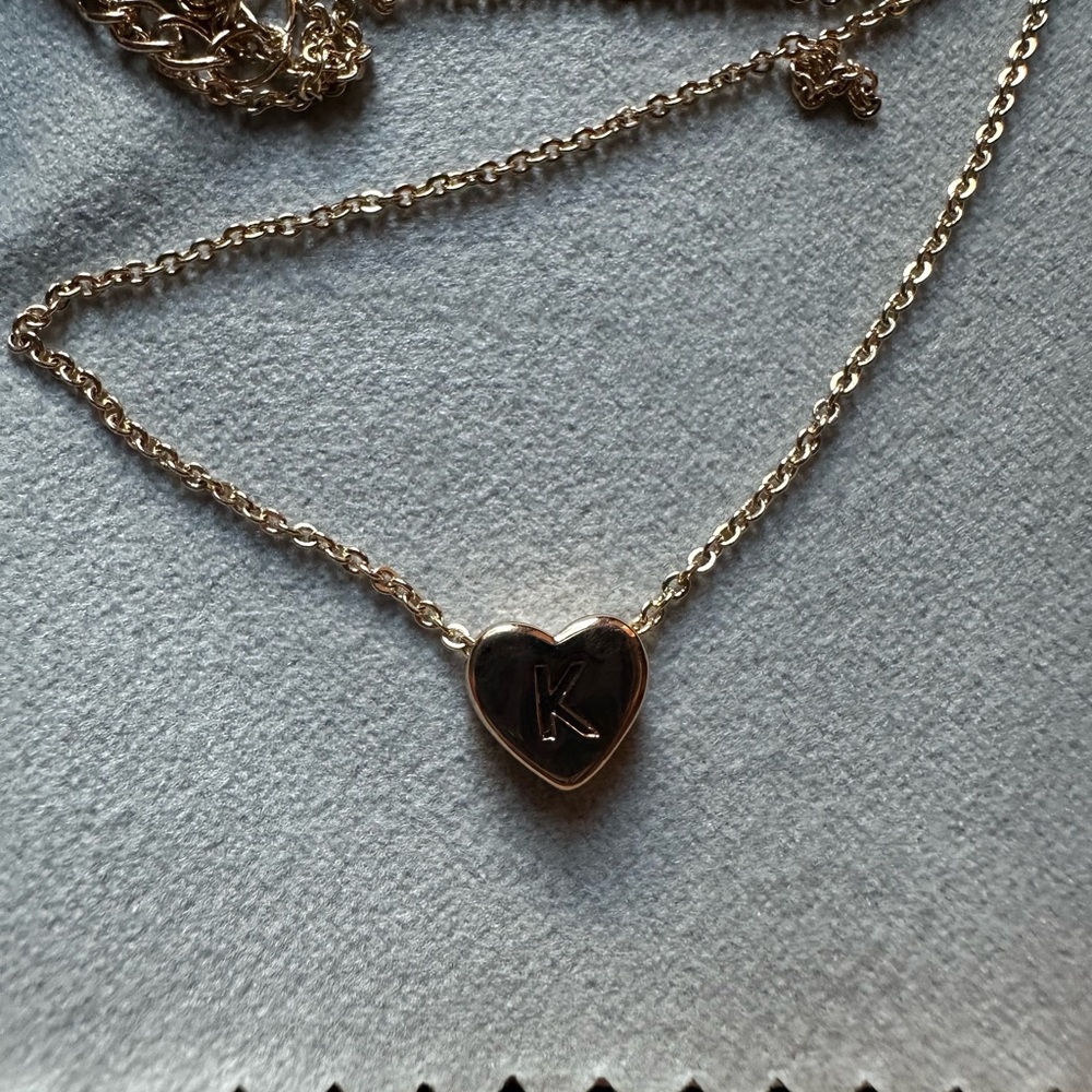gold bracelet with a heart that has a k on it